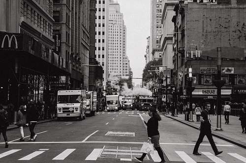 black-and-white woman in black top walking on roadway people