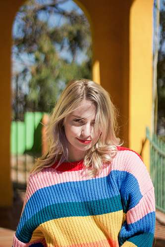apparel woman in red, pink, blue, and yellow striped knit sweater clothing