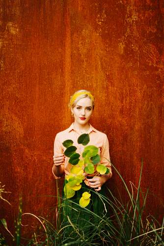 person woman in white long sleeve shirt holding yellow flower plant