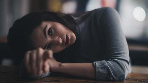person woman leaning on brown wooden surface people