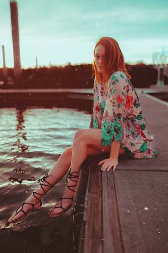 people woman sitting near body of water person
