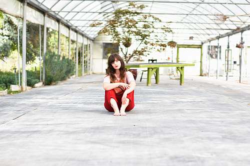 person woman sitting on gray concrete surface posing for photo people