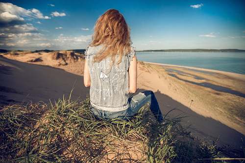 person woman sitting on mountain edge people
