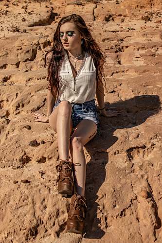 apparel woman sitting on rock during daytime clothing