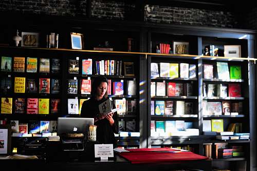 person woman standing in front of book shelf people