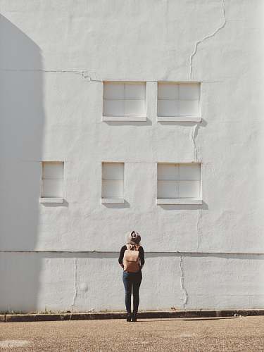 person woman standing on front of white building photographer