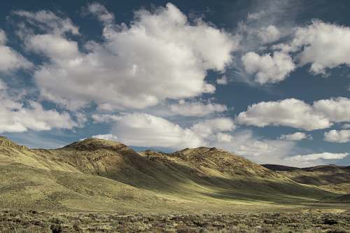 nature landscape photography of mountains covered with green grasses under cloudy sky outdoors