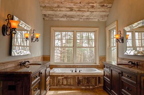 home comfort room with white bathtub and brown wooden cabinets bathroom