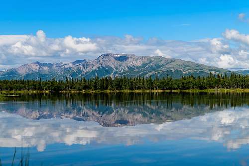 outdoors mountain and blue body of water under cloudy sky water