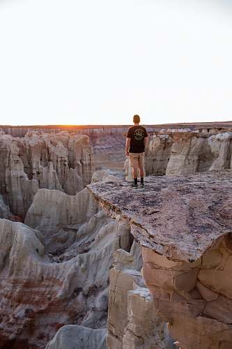 canyon man standing on mountain's edge rock