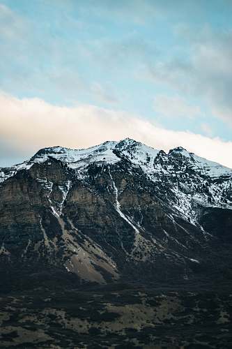 crest snow capped mountain under cloudy sky mountain range