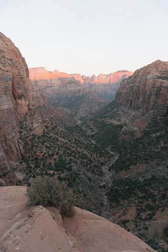canyon aerial photo of cliff under blue sky at daytime mountain