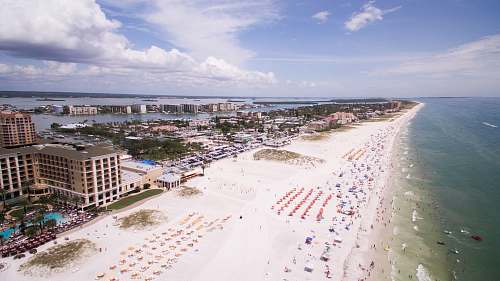 beach aerial photography of people on the beach across buildings at daytime coast