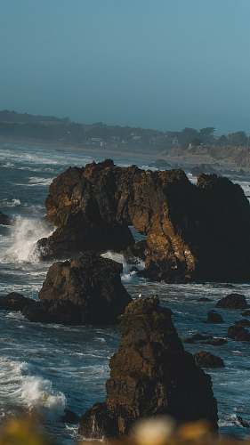 ocean brown rock formation on sea during daytime promontory