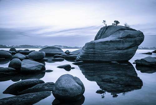 outdoors gray rock formation on body of water during daytime ice