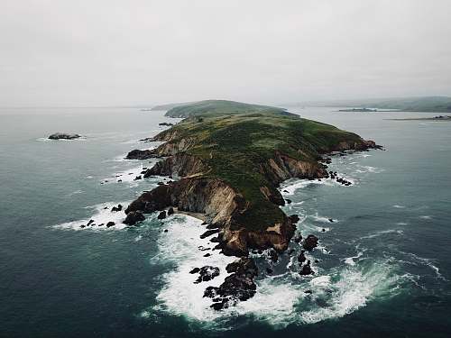 outdoors landscape photography of island surrounded with body of water land