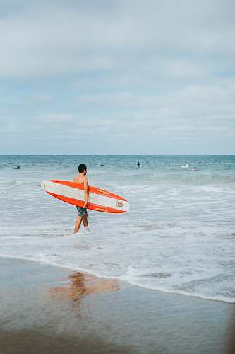 ocean man holding surfboards outdoors
