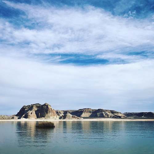 outdoors mountain near the body of water during daytime land