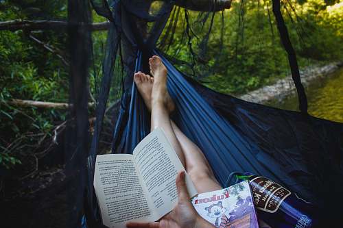 outdoors person holding book hammock