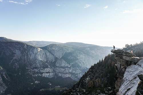 mountain person standing on edge of mountain outdoors
