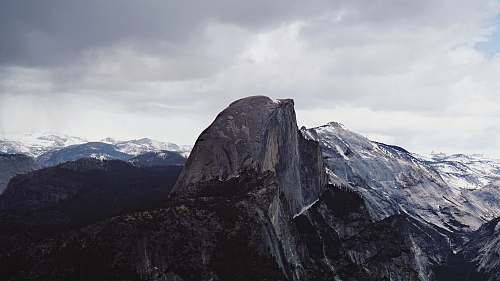 outdoors photo of black and white mountain with snow during daytime mountain