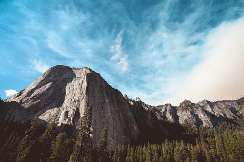 outdoors rock mountain surrounded by pine trees mountain