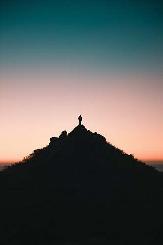 outdoors silhouette of person on top of hill during golden hour sky