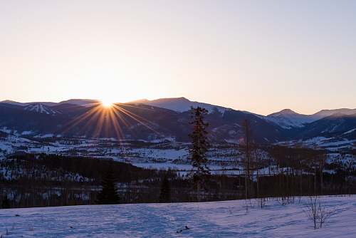 outdoors snow-covered mountains near plain area at sunset sky