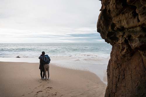 outdoors two person standing on seashore water