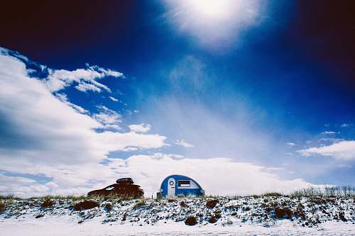 outdoors white and blue trailer under blue calm sky building