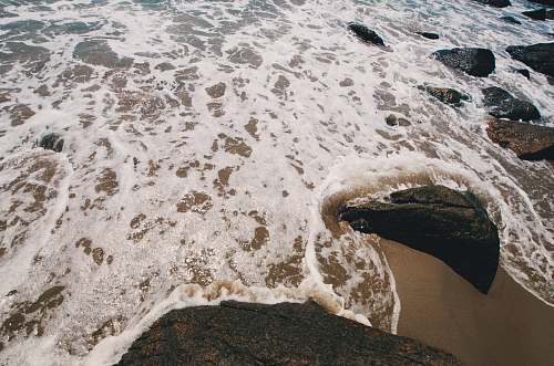 sea body of water beside rocks at daytime water