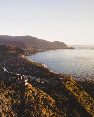 coast houses near body of water and mountain at distance promontory