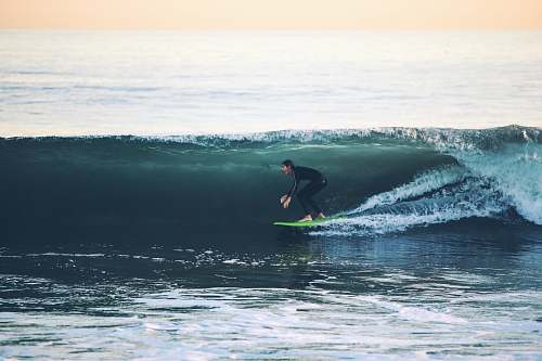 surfing man surfing on sea at daytime water