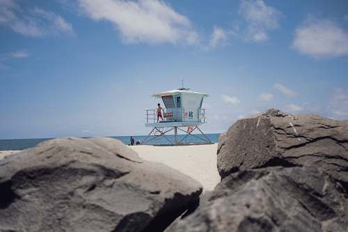 sea person standing on lifeguard tower beacon