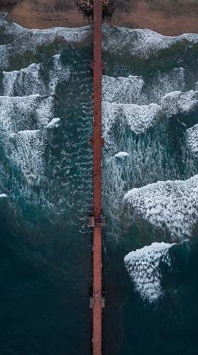 beach aerial photography of boardwalk over sea pier