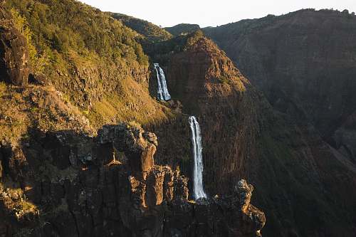 cliff brown rock formation during day time forest