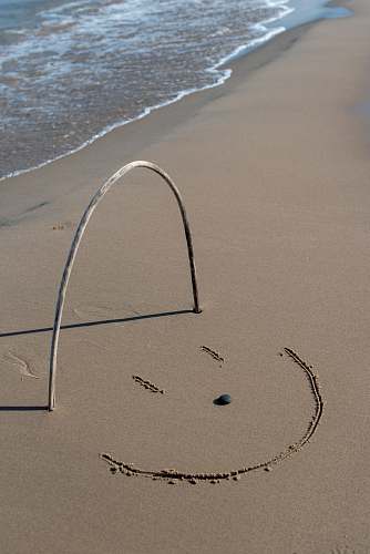 sand grey stick forming u letter on the seashore soil