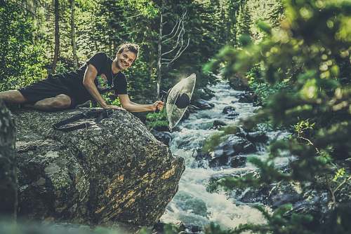 plant man lying on gray rock formation vegetation
