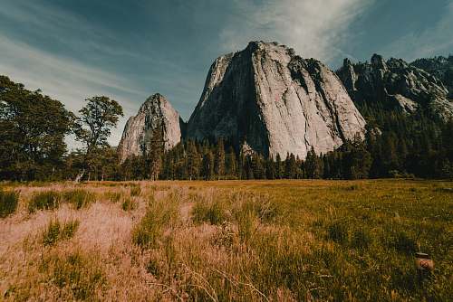 field photography of gray rock formation grassland