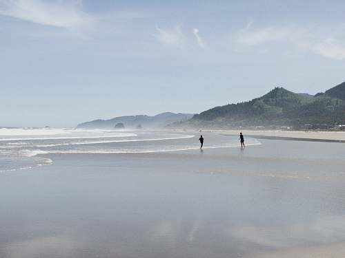 nature two person standing on seashore ocean