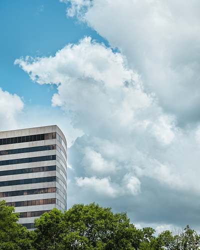 building white concrete multi-storey building under cloudy sky during daytime office building