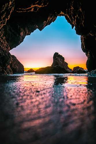 person body of water under rock human