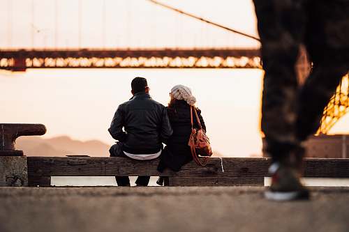 human man sitting beside woman also sitting outside person