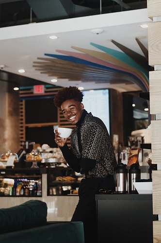 human man standing holding white teacup person