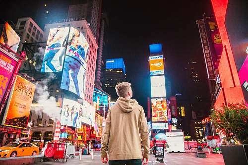 person man standing on road infront of high-rise buildi cab