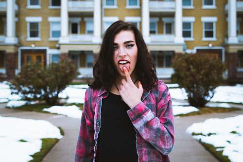 person woman standing putting its finger on her tongue human