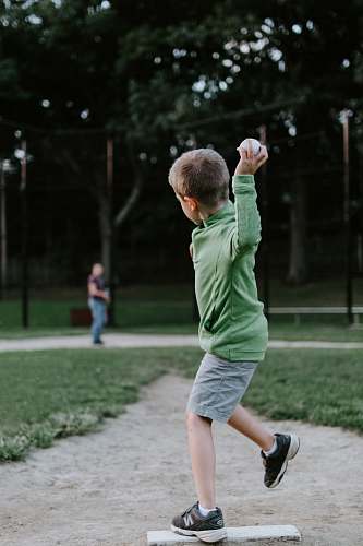 human boy about to throw ball outdoors people