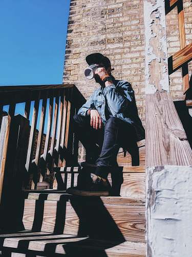 banister man sitting on stair while drinking handrail