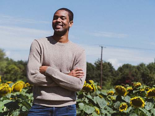 human man smiling while taking photo near the sunflower people