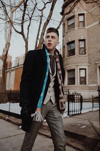 people man wearing black jacket walking on sidewalk human